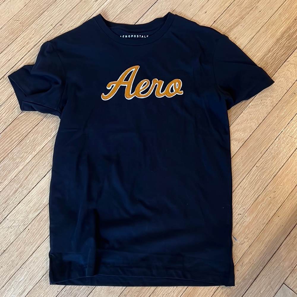 Brand new T-shirt.  Never worn.  Aero.  Black shirt with orange writing.